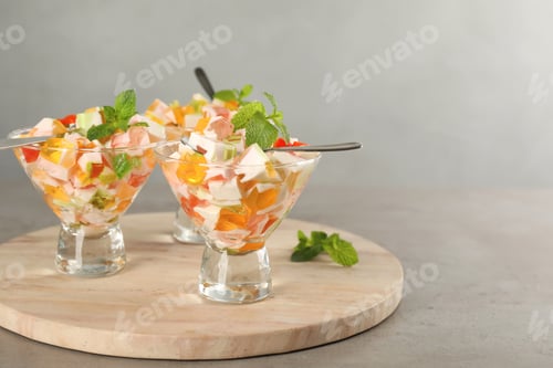 Preview: Delicious broken glass jelly dessert on grey table, space for text
