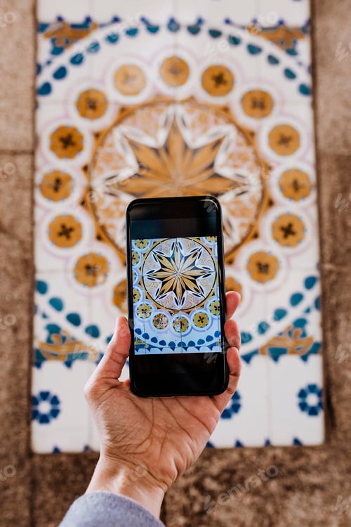 Preview: woman hand taking a picture with mobile phone of portuguese tiles in Oporto