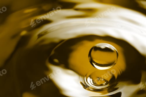 Preview: Splash of golden oily liquid with drop as background, closeup. Space for text