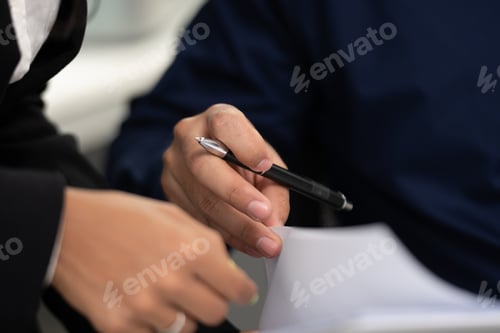 Preview: business man using a pen to sign a agreement document paper to approve by signature