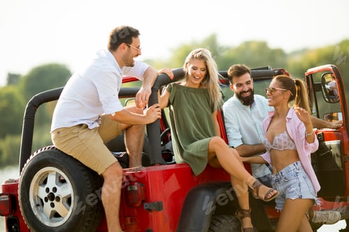 Preview: Group of young people having fun by car outdoor at hot summer day