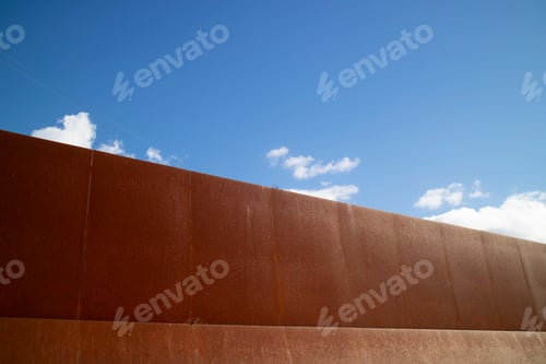 Vista previa: Documentación fotográfica de un muro de hierro arrojado al cielo azul