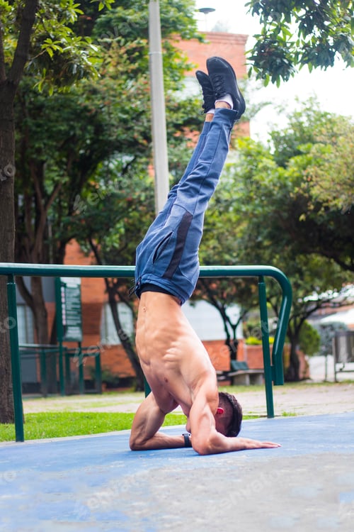 Preview: Hot attractive man doing a handstand in a park