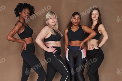 Preview: Results of workout. Group of multi ethnic women standing in the studio against brown background