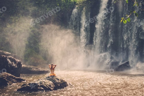 Preview: Beautiful woman sitting near waterfall enjoying the sun, Phnom Koulen at Siem Reap, Cambodia
