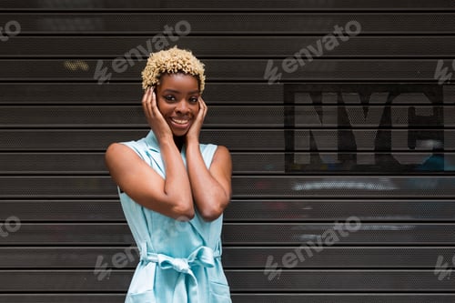 Visualização: EUA, Nova York, jovem afro-americana loira feliz, sorrindo, mão na cabeça