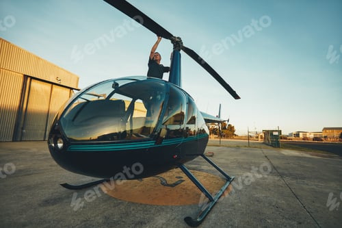 Preview: Pilot inspecting the rotor blades of a helicopter