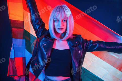 Preview: Holding LGBT flag. Woman with white hair is in studio with neon colors