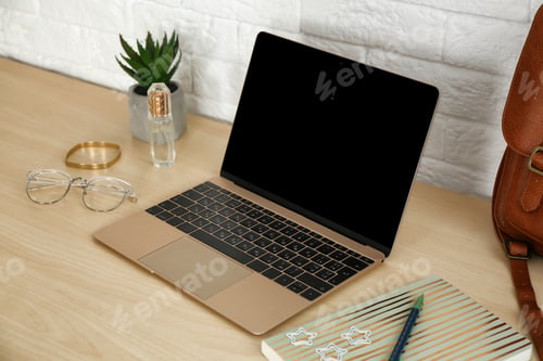 Preview: Stylish workplace with modern laptop on table near brick wall. Fashion blogger