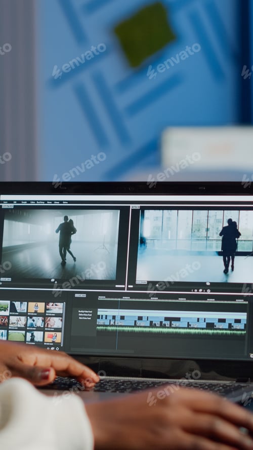 Preview: African videographer working at laptop from office editing video project