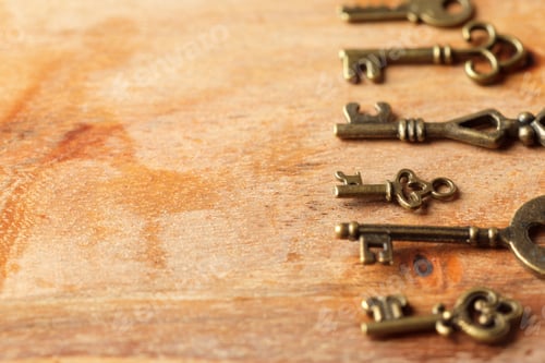 Preview: Collection of antique keys lined up on wooden surface for vintage decor inspiration