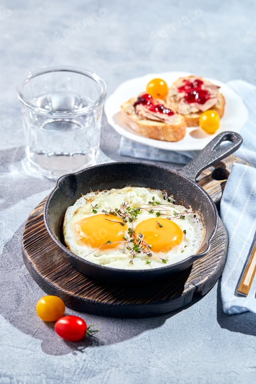 Preview: Fried eggs in cast-iron skillets. Sunny morning breakfast concept