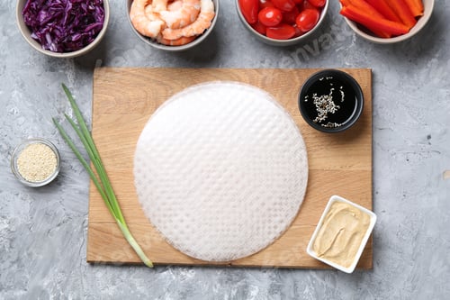Preview: Rice paper sheets and different ingredients on light grey table, flat lay