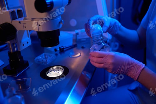 Preview: Female scientist using oil overlay for embryos in Petri dish