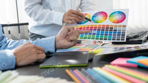 Preview: Graphic designer or creative working together coloring using graphics tablet and a stylus at desk wi