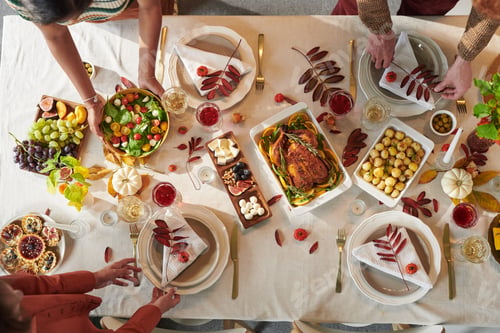 Preview: Multiethnic Adults Sharing Thanksgiving Meal Around Table during Holiday Gathering