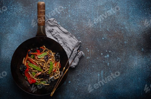 Preview: Asian stir fry noodles with vegetables in black wok pan copy space