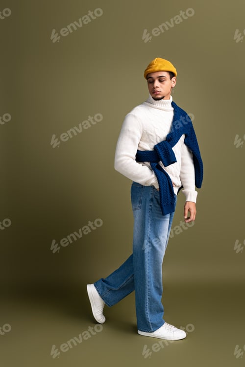 Preview: Fashionable young man showcasing trendy attire in a stylish studio setting