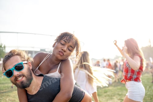 Preview: Multiethnic group of people having fun at summer music festival