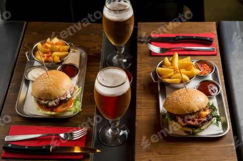 Preview: hamburger with potatoes and beer over restaurant table