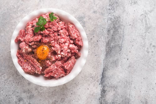 Preview: Raw minced meat. Ground meat beef, pork or lamb spices, herbs and eggs on white plate on light grey