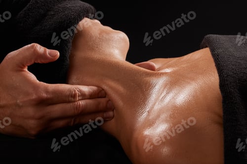 Preview: a male masseur massages a girl's neck on a dark background, neck massage