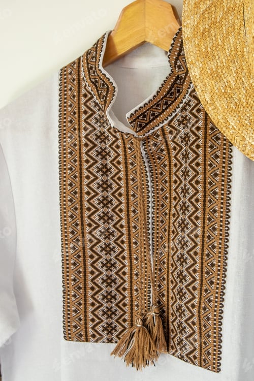 Preview: Ukrainian clothes embroidered shirt. Brown beige and white black threads background. Vyshyvanka