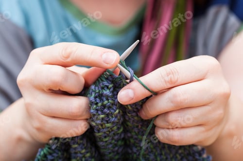 Preview: Hands Knitting with Green and Purple Yarn