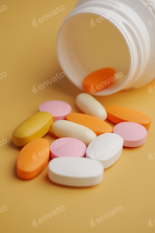 Preview: An Array of Assorted Vitamins and Medications Displayed on a Bright Yellow Surface
