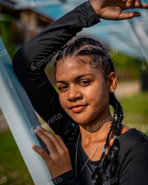Preview: Vertical of a beautiful young woman in a black shirt posing outdoors