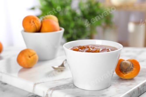 Preview: Bowl with tasty apricot jam on table