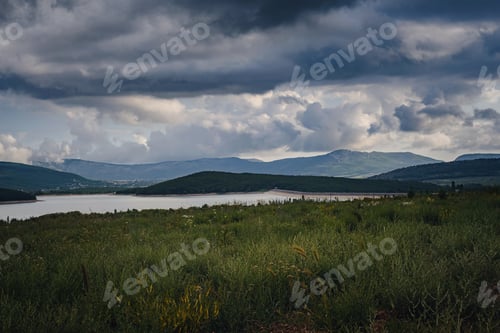 Preview: A lake in the valley among the mountains before it rains.