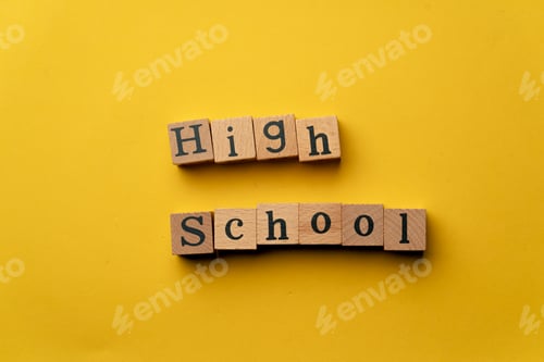 Preview: a yellow warm background without shadows wooden cubes with black letters laid out word high school