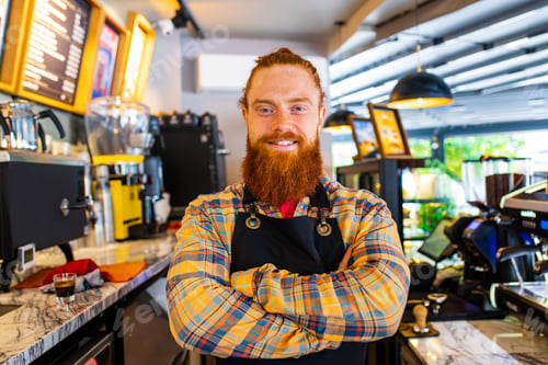 Preview: Professional barista young redhaired ginger bearded man in black apron working in coffee shop