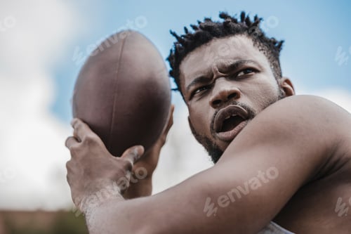 Preview: young handsome african american male football player with ball