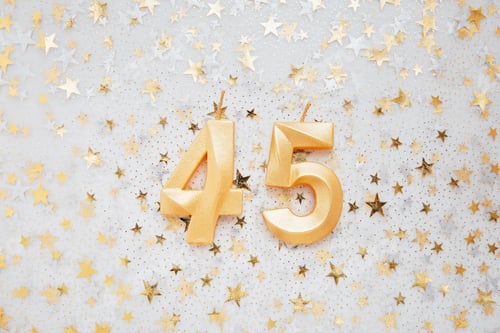 Preview: Number 45 forty five golden celebration birthday candle on Festive Background.