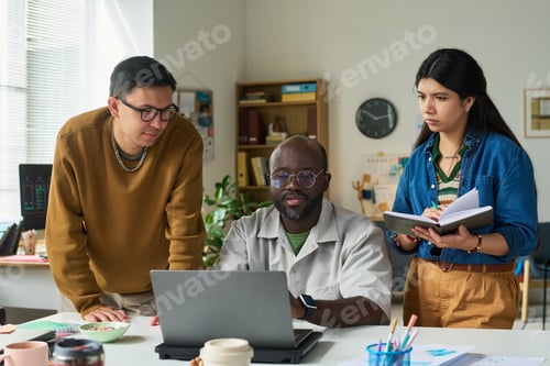 Preview: Multiethnic Adults Collaborating Around Laptop during Office Meeting
