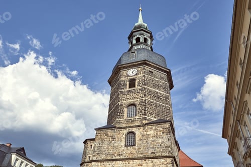 Preview: low angle view of old historical church of St John with clock against blue sky in Bad Schandau,