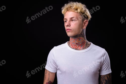 Preview: Young handsome rebellious man with blond hair against black back