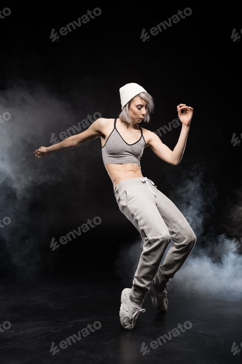 Preview: woman in sports clothing dancing on black