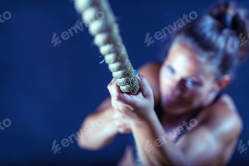 Preview: Woman athlete exercising on gymnastic rings
