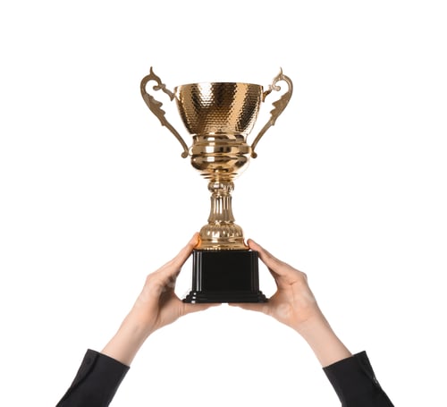 Preview: Woman with golden trophy cup on white background, closeup