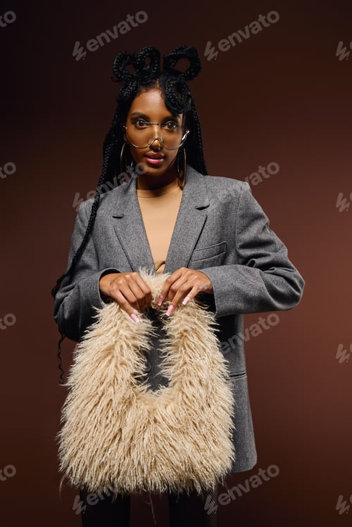 Preview: Fashionable Woman Holding Beige Bag Against Brown Background
