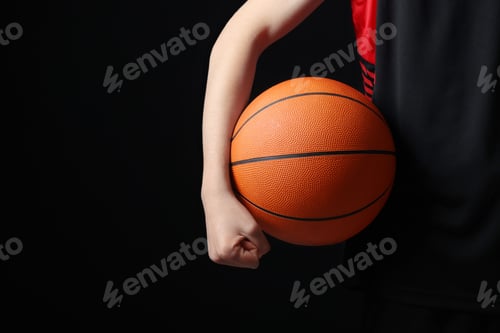 Preview: Boy with basketball ball on black background, closeup. Space for text