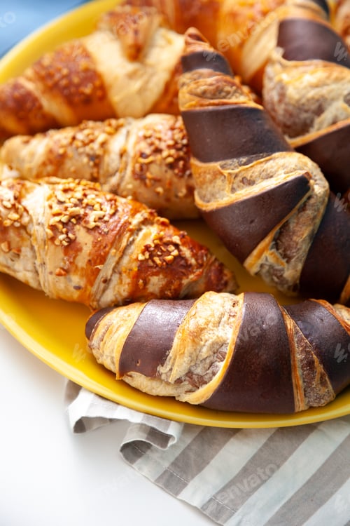 Preview: Chocolate croissants or croissant with nut crumbs on a plate. Breakfast on the table. Sweet baking