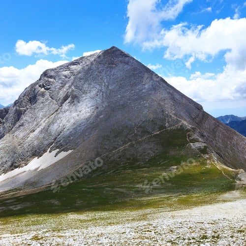 Preview: Scenic view of a mountain peak towering over a rolling landscape of hills