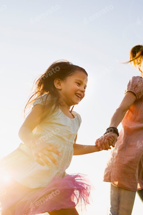 Preview: Mature woman and daughter holding hands and running in park