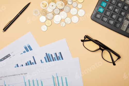 Preview: top view of papers, pen, calculator, coins and glasses on table