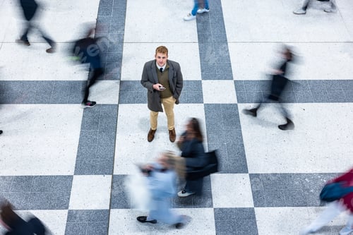 Preview: Businessman standing still in busy urban crowd