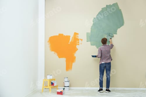 Preview: Young man painting wall indoors, space for text. Home repair